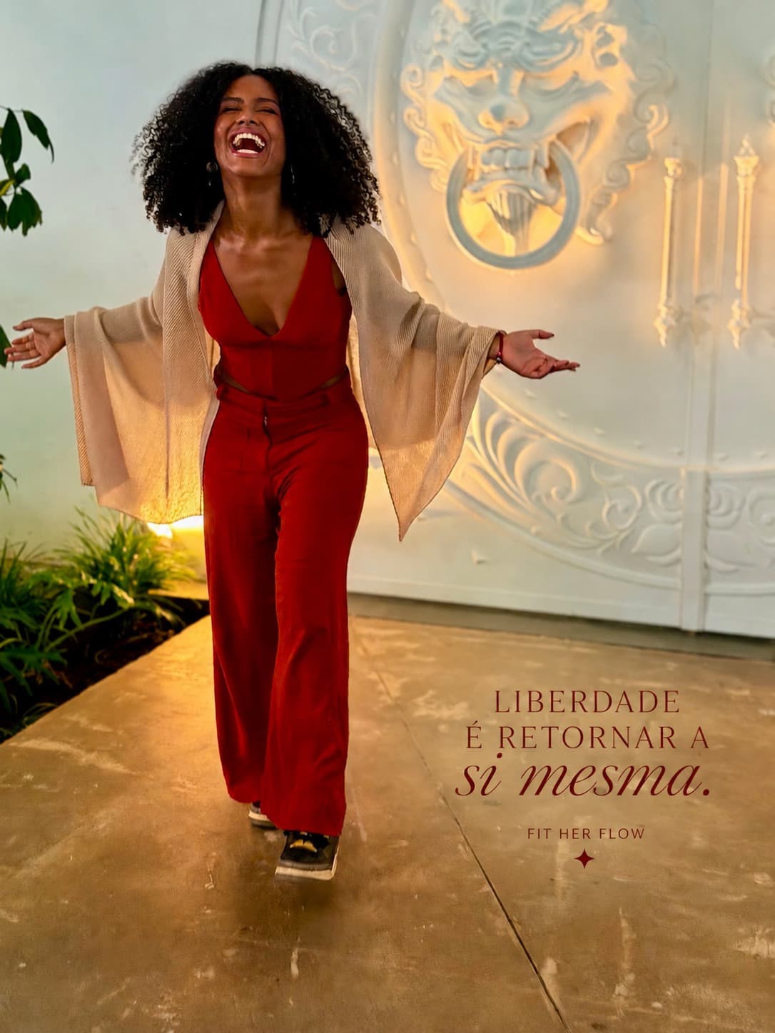 Jéssica Alexandre de vermelho, rindo de braços abertos